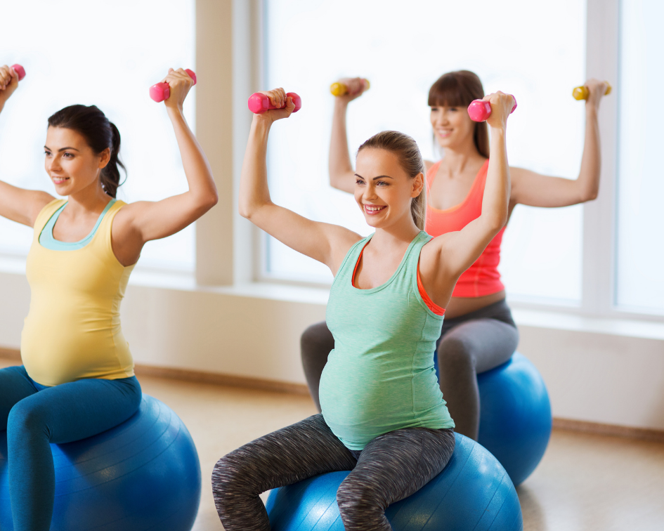 Pregnant ladies exercising on an exercise ball with weights in their hands